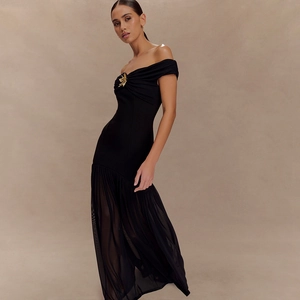 Détail d'un ornement papillon doré élégant sur une robe de soirée noire à épaules dénudées