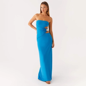 Détail de la découpe latérale et de la boucle fleurie dorée sur la robe longue bleue