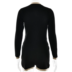 Back view of a black knitted two-piece set with cream contrast trim on a clear mannequin