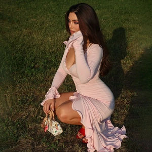 Détail de la robe maxi rose avec manches évasées à volants et décolleté en V à boutonnage