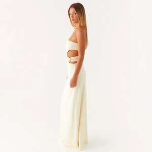 Détail de la découpe latérale et de la fleur 3D sur cette robe longue bustier crème chic