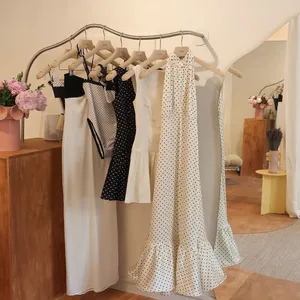 Robe longue dos nu à pois et vêtements d'été exposés sur des cintres élégants