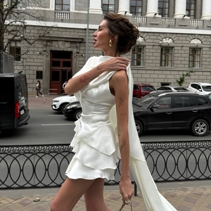 Détail d'une robe blanche en satin sans manches avec ourlet à volants et longue traîne