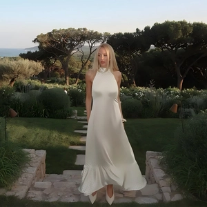 Détail de la robe licou en satin blanc avec bordure en strass et ourlet à volants