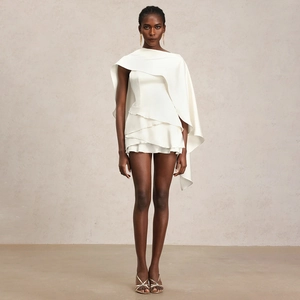 Gros plan détaillé de la robe en satin blanc avec cape asymétrique et volants étagés