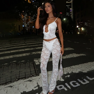 Ensemble chic en dentelle blanche avec haut dos nu ajouré et pantalon évasé en ville
