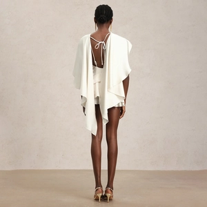 Détail de la robe dos nu en satin blanc avec manches cape et nœud délicat à l'arrière