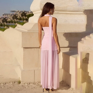 Détail d'une robe rose avec bustier plissé, empiècements en tulle et longs rubans fluides