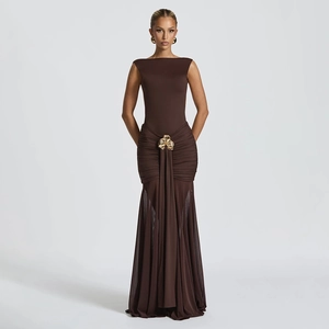 Detail of elegant gold floral metal buckle on waist of dark brown pleated fishtail dress