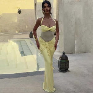Detail of elegant yellow halter neck maxi dress with mesh panels and ruched waist texture