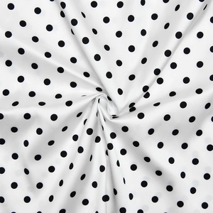 Gros plan du tissu à pois soyeux montrant la texture douce et le drapé de qualité