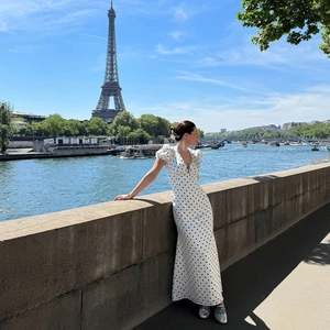 Polka dot V-neck midi dress with puff sleeves shown against the Eiffel Tower background