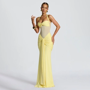 Detail of sheer mesh patchwork and ruched waist on a light yellow halter neck maxi dress