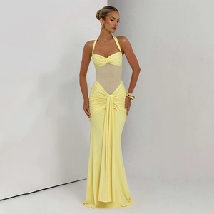 Detail of light yellow halter evening dress with ruched waist and sheer mesh panels