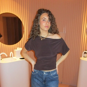 Dettaglio del top marrone scuro con spalle scoperte a pois e vestibilità slim