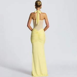 Detailed back view of a light yellow halter dress with a large elegant bow and ruched texture