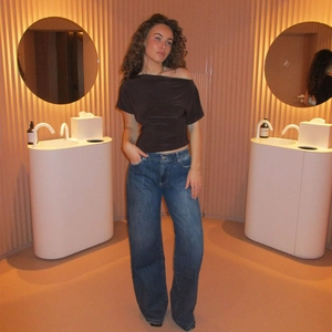 Top marrone attillato con spalle scoperte e jeans blu a gamba larga a vita alta chic