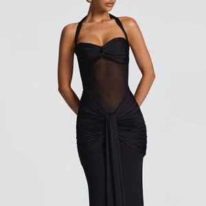 Close-up of ruched black halter dress showing sheer mesh stitching and knotted bust detail