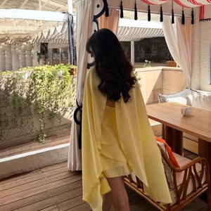 Élégante robe satinée sans manches jaune clair avec volants superposés et cape