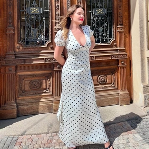 Detailed view of the V-neckline and elegant puff sleeves on white polka dot maxi dress