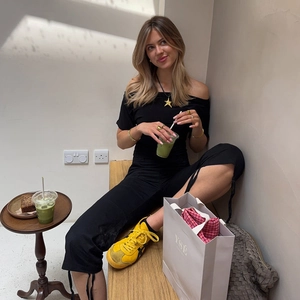 Top a pois a spalle scoperte abbinato a pantaloni neri con coulisse e scarpe gialle