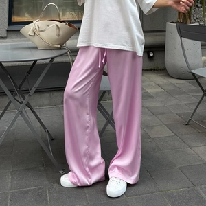 Detaillierte Nahaufnahme der rosa Satinhose mit seidigem Glanz und Kordelzug an der Taille