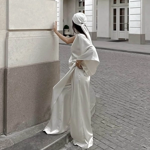 Détail d'un ensemble 3 pièces en satin blanc avec haut asymétrique et pantalon large