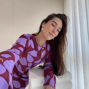 Détail d'une robe longue rétro à imprimé feuilles abstraites et collier doré chic