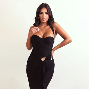 Detail of black halter evening dress featuring a gold leaf buckle and pleated waist