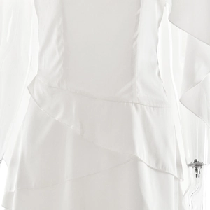 Détail d'une robe élégante en satin blanc montrant les volants et la texture soyeuse