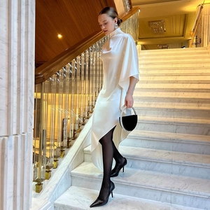 Détail d'une robe en satin blanc élégante avec ourlet irrégulier et col montant