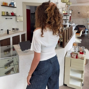 T-shirt sexy a pois con spalle scoperte e pantaloni larghi per un look estivo chic