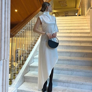 Détail d'une robe en satin blanc élégante avec col montant et une silhouette asymétrique