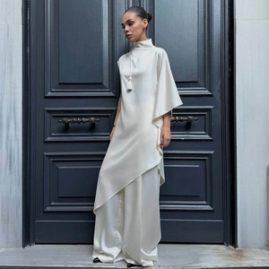 Détail de l'ensemble deux pièces en satin crème avec haut asymétrique et pantalon