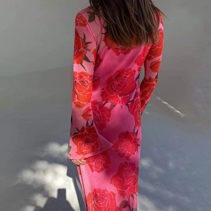 Close-up of semi-transparent mesh fabric with vibrant red rose prints on a pink dress