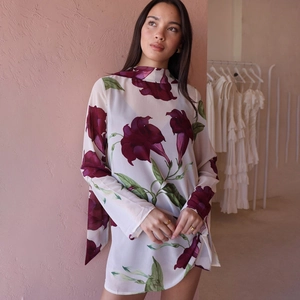 Détail d'une robe en mousseline avec de grands imprimés floraux violets sur fond ivoire