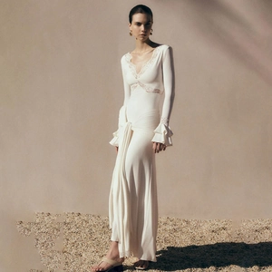 Detail of V-neck lace trim and waist tie drape on an elegant white long sleeve dress