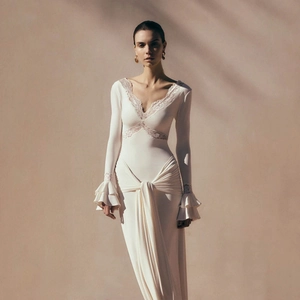 Detail of elegant ivory maxi dress with delicate lace V-neck and ruffled layered sleeves