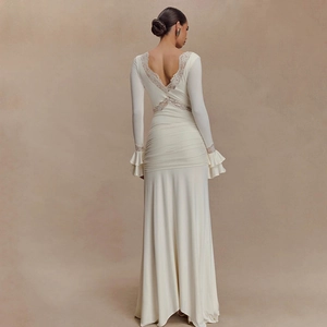 Elegant white backless long dress with lace trim and ruffled sleeves on female model