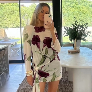 Détail d'une mini robe en mousseline fleurie avec cordon latéral et manches longues