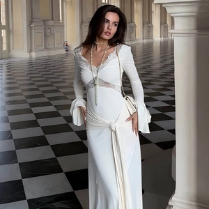 Detailed view of the elegant white lace neckline and knotted ribbon on this slim maxi dress