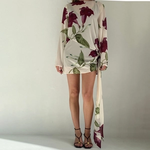 Détail du drapé latéral et du motif floral sur la robe courte en mousseline à manches longues