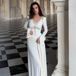 Detail view of the eyelash lace V-neckline and hollow lace waist on a white maxi dress