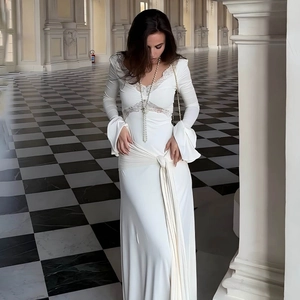 Elegant white slim-fit maxi dress with lace V-neckline and stylish long trumpet sleeves