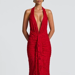 Detailed close-up of the red textured fabric and deep V-neckline on the halter maxi dress