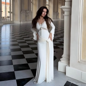 Detail of elegant white long sleeve dress with deep V-neck lace and waist ribbon ties