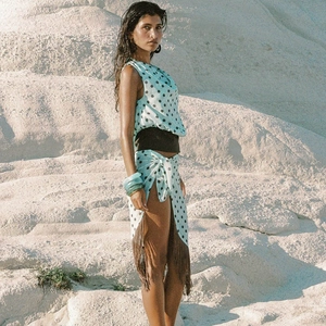Detail of light blue polka dot two-piece set with long fringe skirt and black waist belt