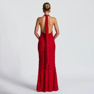 Detail of red halter backless dress featuring 3D floral texture and flowing neck tie