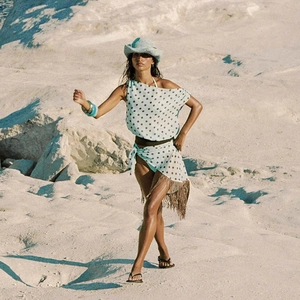 Light blue polka dot two-piece beach set with one-shoulder top and tassel wrap skirt