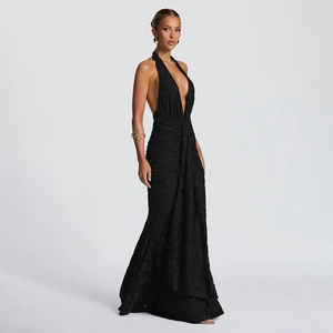 Macro detail of the elegant black halter neck dress showing textured floral jacquard fabric